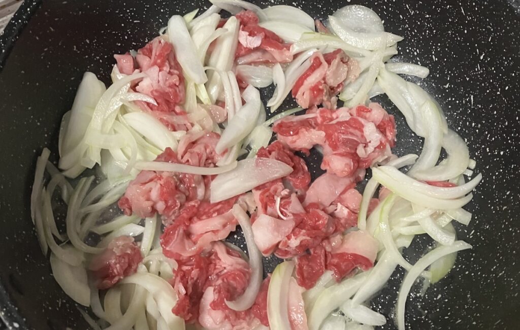 フライパンに玉ねぎ、牛肉を入れた