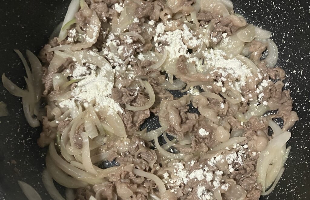 炒めた牛肉に小麦粉を入れた