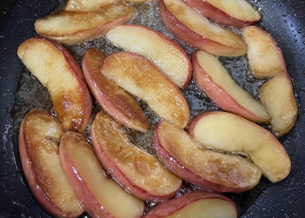 焼き色がついたりんごにグラニュー糖をかけて熱している画像